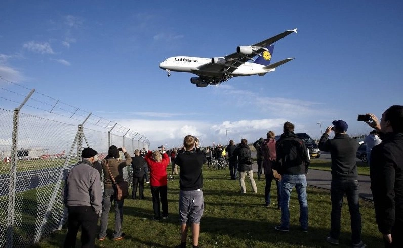 A imagem mostra spotters acompanhando e fotografando o pouso de um a380 nos arredores do aeroporto de Copenhagen, na Dinamarca